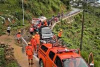 Petugas BPBD Wonosobo membersihkan material longsor yang menutup jalan di Kecamatan Watumalang.