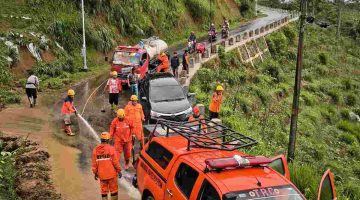 Petugas BPBD Wonosobo membersihkan material longsor yang menutup jalan di Kecamatan Watumalang.