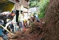 Petugas gabungan membersihkan material longsor yang merusak rumah warga Surengede, Kejajar, Wonosobo.