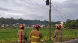 Petugas Damkar saat memadamkan travo yang terbakar.