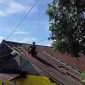 Warga melakukan perbaikan atap yang rusak terkena angin kencang.