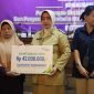 Bupati Purworejo, Yuli Hastuti menyerahkan santunan kematian senilai empat puluh dua juta rupiah kepada ahli waris pekerja rentan yang aktif.